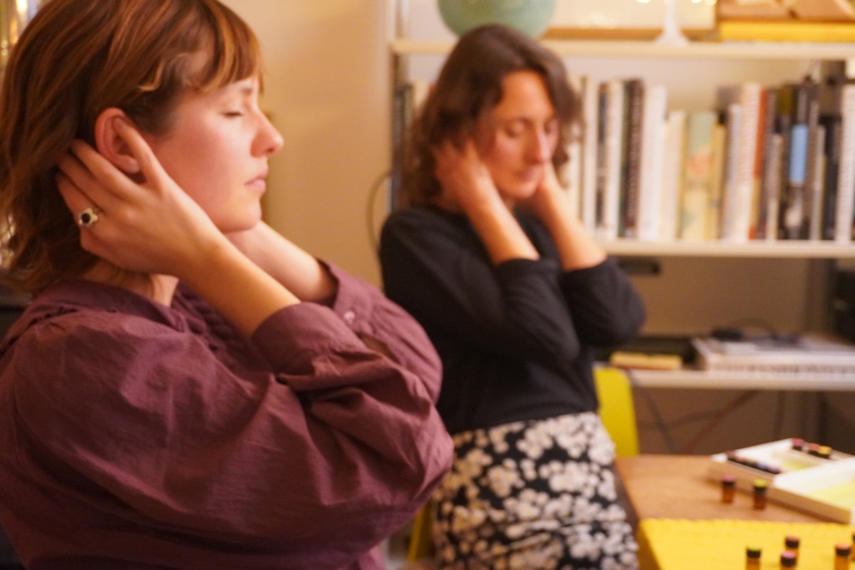 Two women receiving the practice, hands resting at the neck